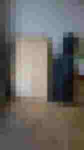 Holzplatten für den Instrumentenbau und eine Instrumententasche stehen auf einem Parkettboden.