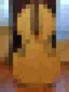 Gehobenes Holz-Instrument mit Schalllöchern, bereit für Reparatur und Restauration.