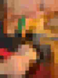 Hände einer Person arbeiten konzentriert an einem Holzstück für ein Musikinstrument.