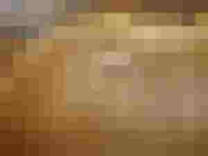 Detailaufnahme eines reparierten Holz-Instrumentes mit sichtbaren Rissflicken und Maserung.