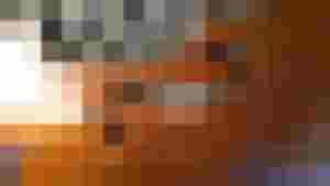 Detailaufnahme einer beschädigten Holzoberfläche eines Streichinstruments zur Restauration.